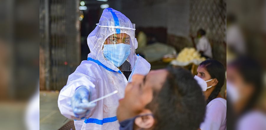 A health worker collects sample for Covid-19 test, at KSRTC bus stand in Bengaluru, Tuesday, Nov. 24, 2020. Credit: PTI Photo