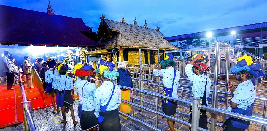 Devotees maintain social distance while standing in queues to offer prayers at Lord Ayyappa temple on the 1st day of Malayalam month of 'Vrischikom, at Sabarimala in Pathanamthitta. Credit: PTI Photo