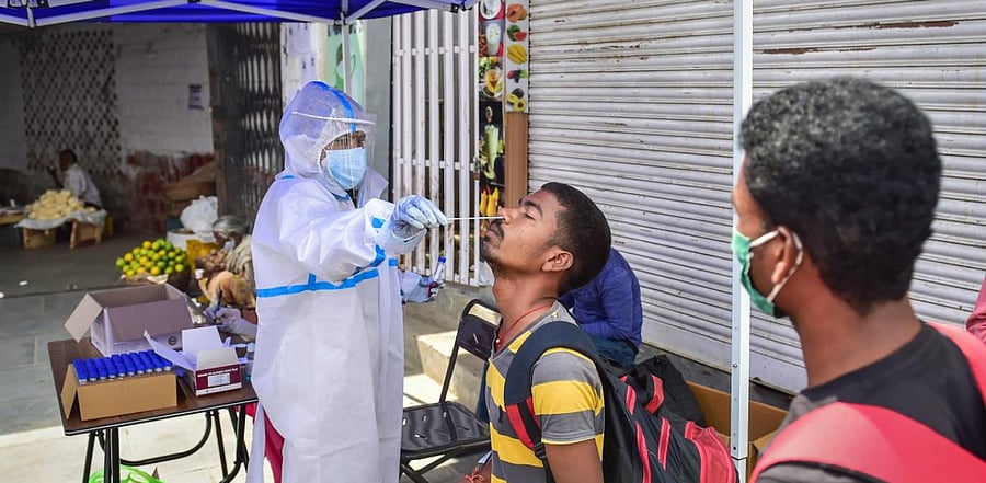 A health worker collects samples for Covid-19 tests, at Majestic Bus Stand in Bengaluru. Credit: PTI Photo