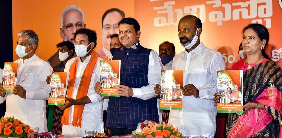 Senior BJP leader Devendra Fadnavis along with party National General Secretary Bhupendra Yadav (R), Telangana BJP Chief Bandi Sanjay Kumar (2L) and State Home Affairs Minister G. Kishan Reddy (2R) releases the party's GHMC manifesto, in Hyderabad. Credit: PTI.