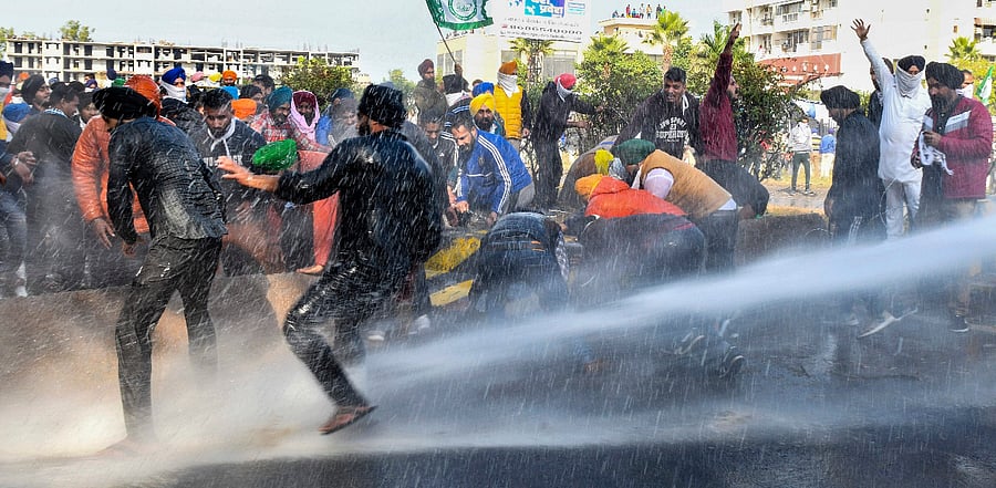 Police personnel use water canons on farmers to stop them from crossing the Punjab-Haryana border during 'Delhi Chalo' protest march against the new farm laws, near Ambala. Credit: PTI Photo