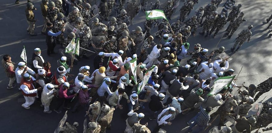 Bharatiya Kisan Union (BKU) members attempt to cross a police barricade at Ghazipur border during their 'Delhi Chalo' march against the new farm laws, in New Delhi, Saturday, Nov. 28, 2020. Credit: PTI Photo