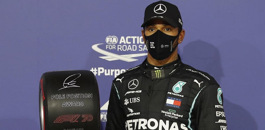 Mercedes' Lewis Hamilton celebrates with an award after qualifying in pole position. Credit: Reuters Photo