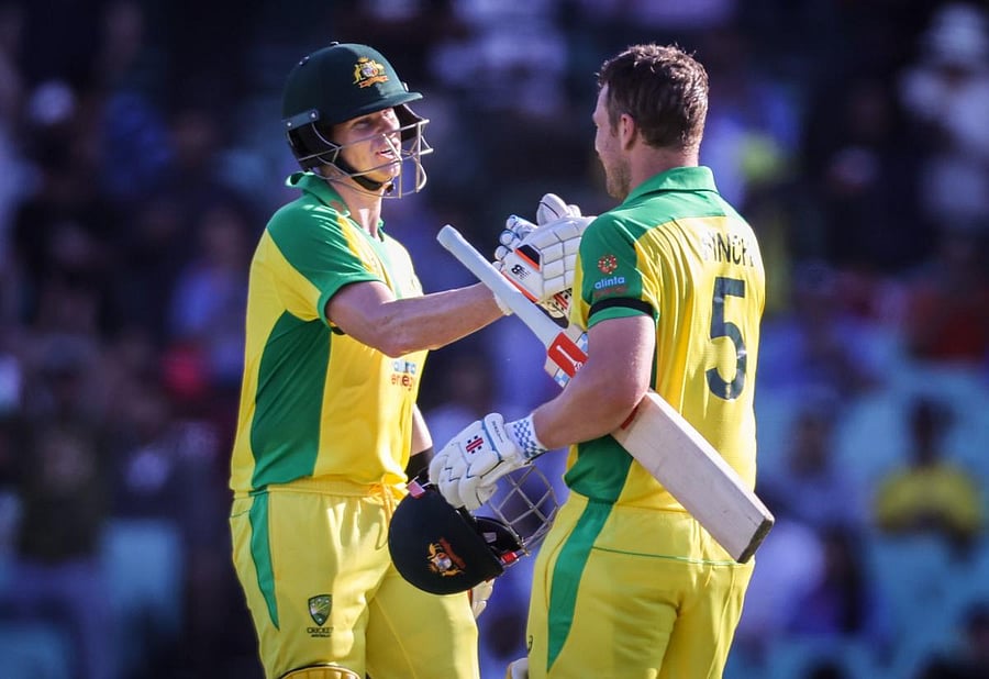 Australia's captain Aaron Finch (R) celebrates reaching his century with teammate Steve Smith during the one-day international cricket match against India at the Sydney Cricket Ground (SCG) in Sydney on November 27, 2020. Credit: AFP