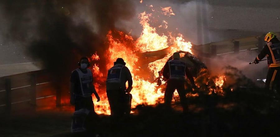 Fire marshals put out a fire on Haas F1's French driver Romain Grosjean's car during the Bahrain Formula One Grand Prix at the Bahrain International Circuit in the city of Sakhir on November 29, 2020. Credit: AFP Photo