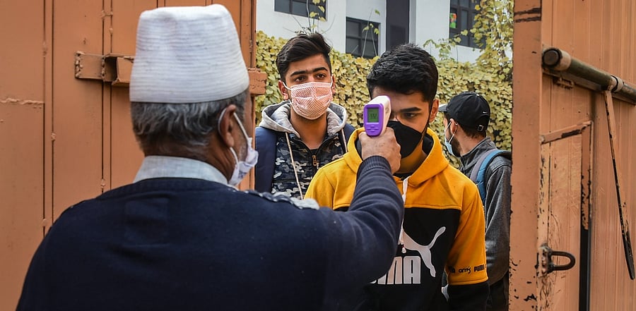 Students undergo thermal screening as they arrive to appear in class 10th examination, at a school in Srinagar. Credit: PTI Photo