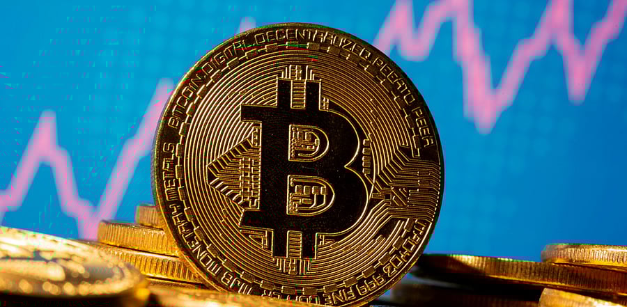 A representation of virtual currency Bitcoin is seen in front of a stock graph. Credit: Reuters Photo