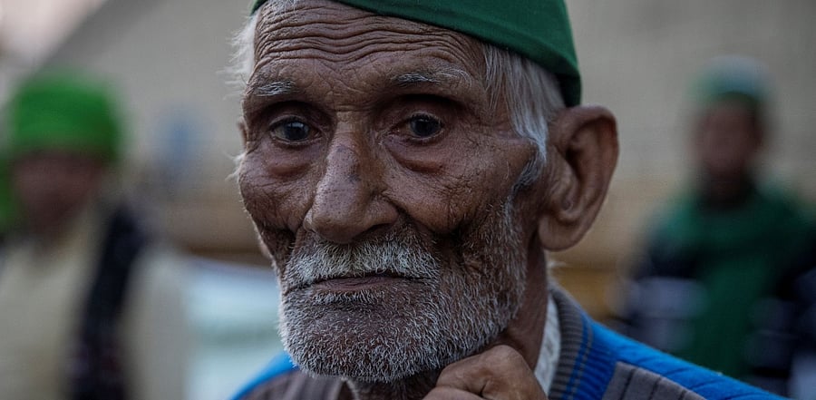 Sauran Singh, 97, a farmer, stands in front of police barricades as he attends a protest against the newly passed farm bills at the Delhi-Uttar Pradesh border in Ghaziabad. Credit: Reuters Photo