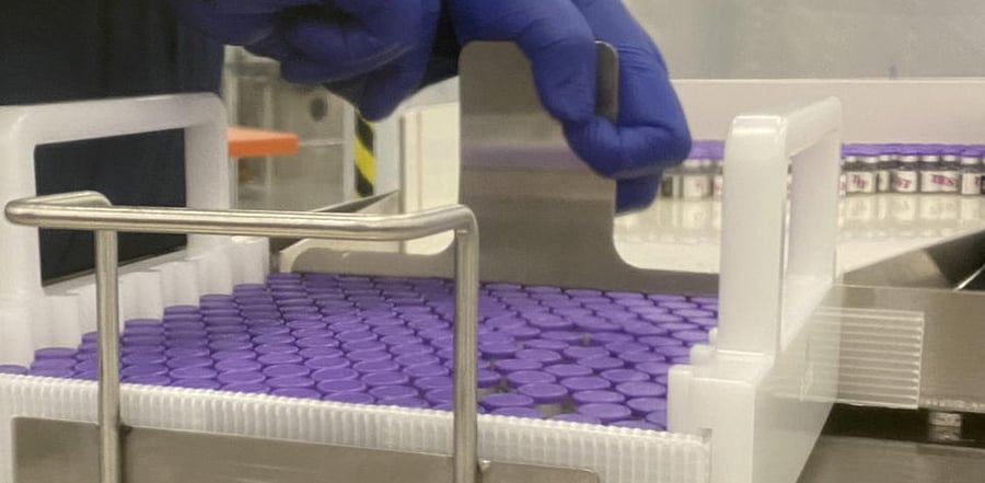 Vials are seen as an employee works on the coronavirus disease (COVID-19) vaccine at the Pfizer manufacturing facility in Kalamazoo, Michigan, U.S., in this undated handout photo. Credit: Reuters Photo