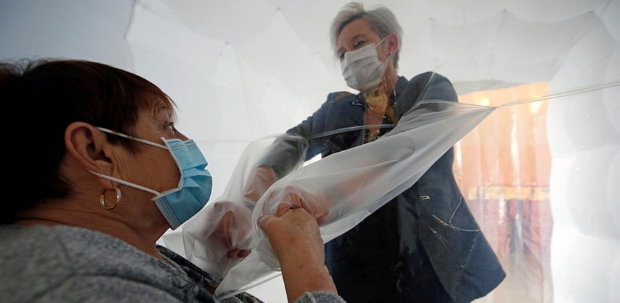 Inflatable tunnel and plastic sleeves allows people to hug and touch. Credit: Reuters Photo