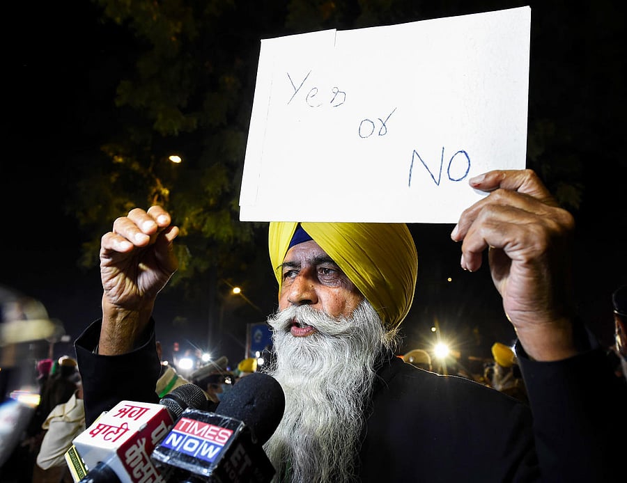 A farmer leader holds placards as he addresses media after a meeting with Union Minister Narendra Singh Tomar over the Center's new farm laws, outside Vigyan Bhawan in New Delhi, Saturday, Dec. 5, 2020. Farmers' group went on a 'maun vrat' (vow of silence) during their fifth round of talks with the government and sought a reply in 'yes' or 'no' on their key demand of repealing the three new farm laws. Credit: PTI Photo