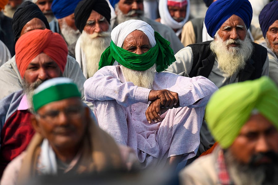 Farmers listen a speech along a highway blocked by police with barricades to stop farmers from marching to New Delhi to protest against the central government's recent agricultural reforms at the Delhi-Uttar Pradesh state border in Ghazipur on December 6, 2020. Credit: AFP Photo