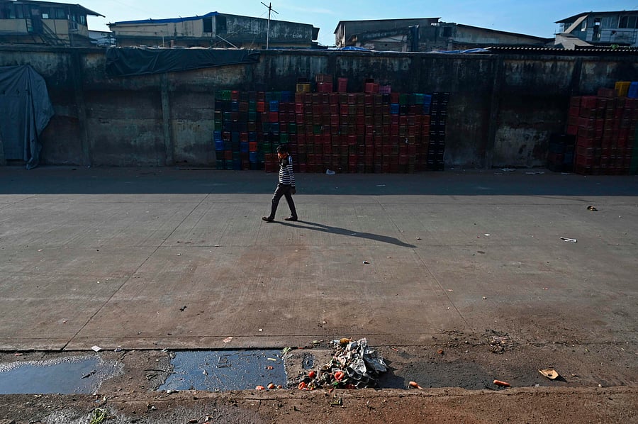 A worker walks through an empty parking area of the Agricultural Produce Market Committee (APMC) yard. Credit: AFP Photo