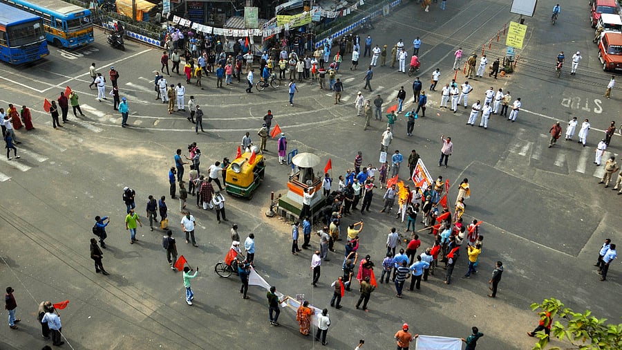 Communist Party of India (CPI) activists block Hazra crossing during a protest in support of the nationwide strike, called by agitating farmers to press for repeal of the Centre's agri-laws, in Kolkata. Credit: PTI Photo