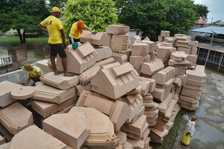 Workers clean stone blocks, to be used in construction of the Ram Temple, at a workshop in Ayodhya. Credit: PTI photo.