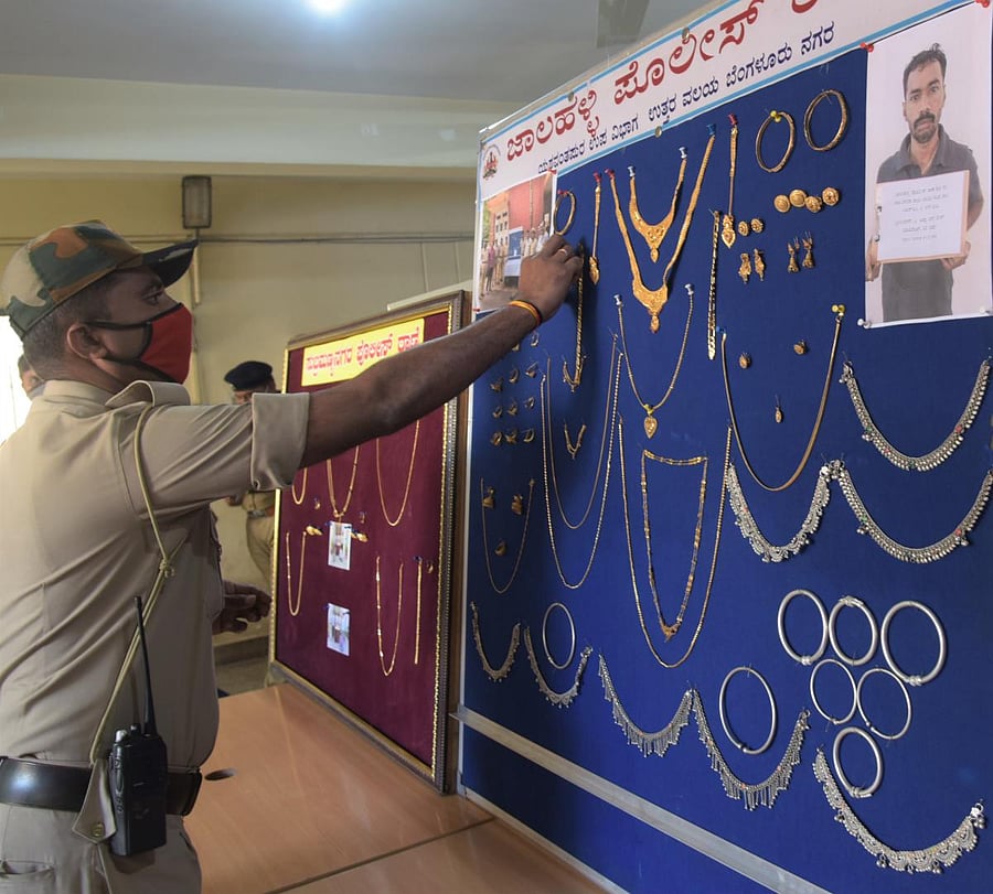 A policeman looks at the recovered jewellery at the office of the DCP (North) on Friday. DH PHOTO/B H SHIVAKUMAR
