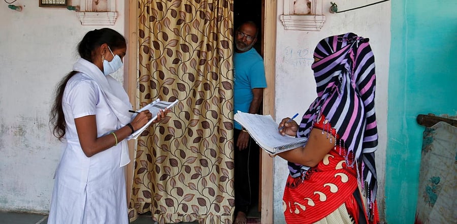 Health workers collect personal data from a man as they prepare a list during a door-to-door survey for the first shot of Covid-19 vaccine for people above 50 years of age and those with comorbidities, in a village on the outskirts of Ahmedabad. Credit: Reuters.
