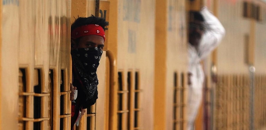 A man looks out of a train as it arrives at a platform amid the spread of the coronavirus disease (COVID-19), at a railway station in Mumbai, India, December 11, 2020. Credit: Reuters Photo