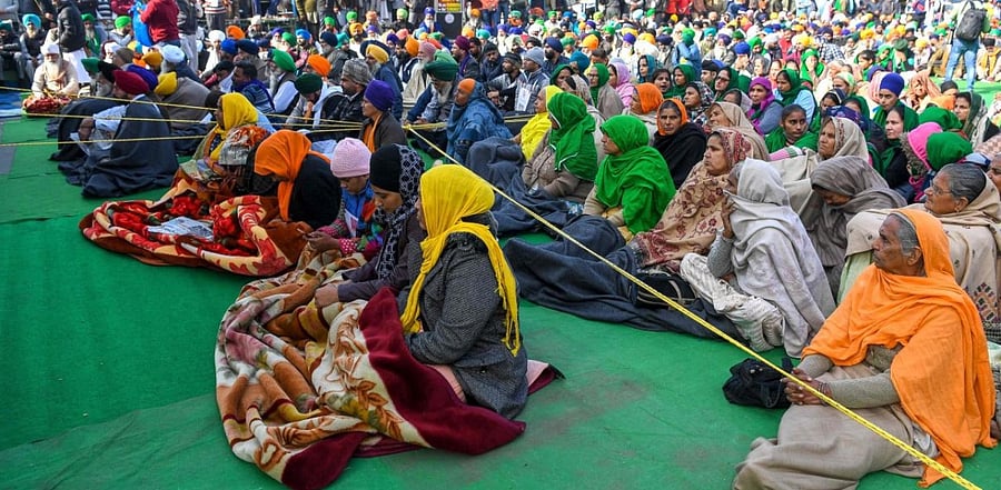 Farmers listen to the leaders speech next to barricades during a protest against the recent agricultural reforms, at the Delhi-Haryana state border in Singhu. Credit: AFP photo.