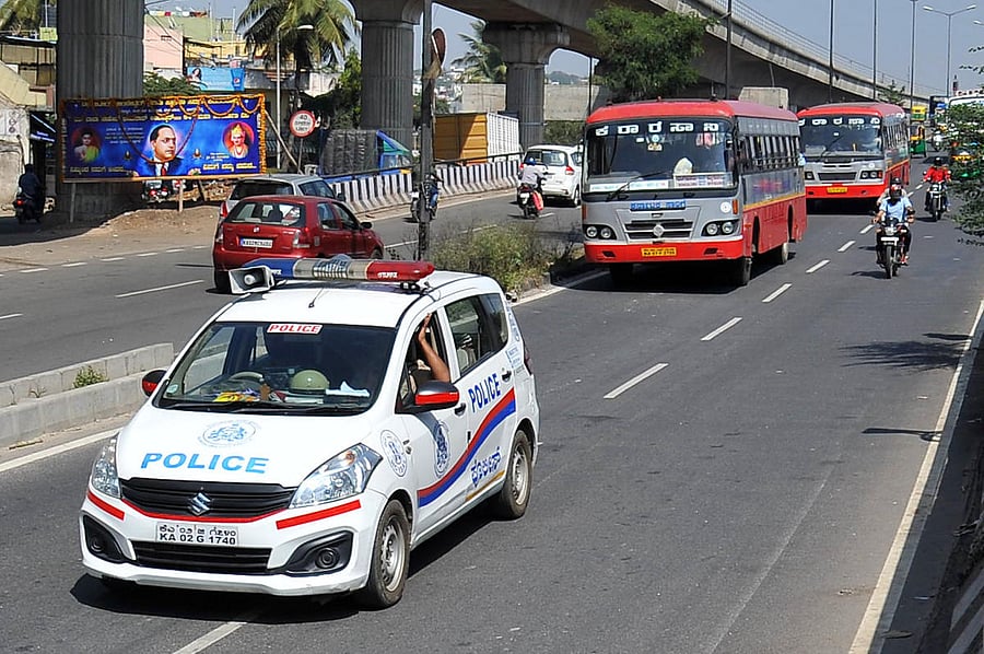 A police patrol car escorts KSRTC buses on the third day of the transport workers' strike in Bengaluru on Sunday, December 13, 2020. Credit: DH PHOTO/PUSHKAR V