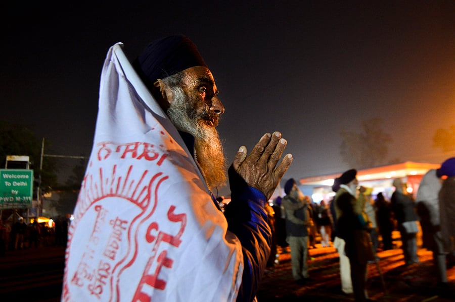  A Sikh farmer offer prayers at Singhu border during a protest against the Centre's agri-laws in New Delhi, Wednesday, Dec. 16, 2020. Credit: PTI Photo