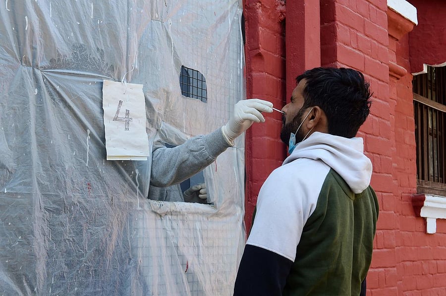 A health official takes a swab sample from a man to test for the Covid-19 coronavirus at a testing centre in Allahabad. Credit: AFP