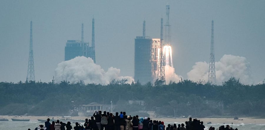 People watch a Long March-8 rocket, the latest China's Long March launch vehicle fleet, lifting off from the Wenchang Space Launch Center in southern China's Hainan province. Credit: AFP.