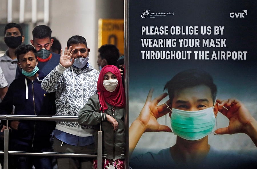 People wearing protective face masks wait for passengers to arrive at Chhatrapati Shivaji Maharaj International Airport after India cancelled all flights from the UK over fears of a new strain of the coronavirus disease, in Mumbai. Credit: Reuters.