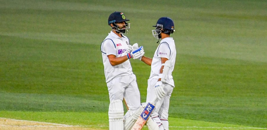 India's captain Virat Kohli celebrates reaching his half century (50-runs) with a teammate Ajinkya Rahane (R). Credit: AFP Photo
