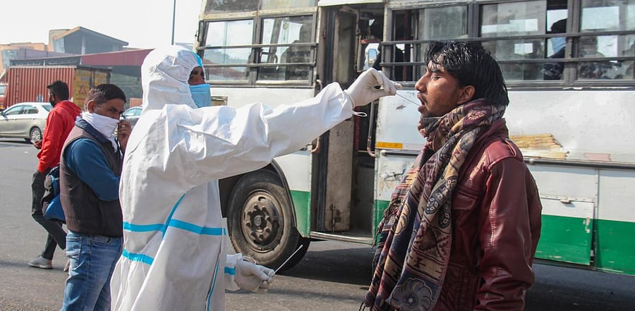 A health worker conducts Covid-19 tests of people coming from other states at Kherki Daula toll plaza, in Gurugram. Credit: PTI