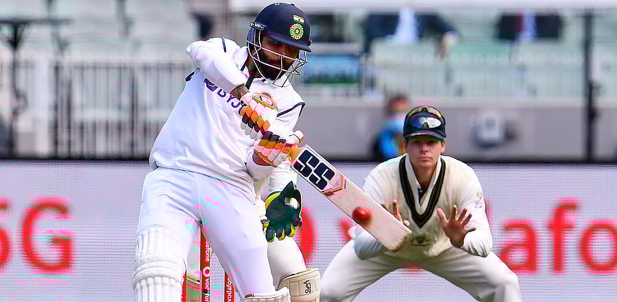 Ravi Jadeja plays a shot as Australia's Steve Smith (R) looks on during the day three of the second cricket Test match between Australia and India at the MCG in Melbourne. Credit: AFP Photo