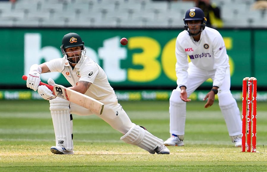 Australia's Matthew Wade (L) plays a shot as India's Shubman Gill looks on during the third day of the second cricket Test match between Australia and India at the MCG in Melbourne on December 28, 2020. Credit: AFP. 