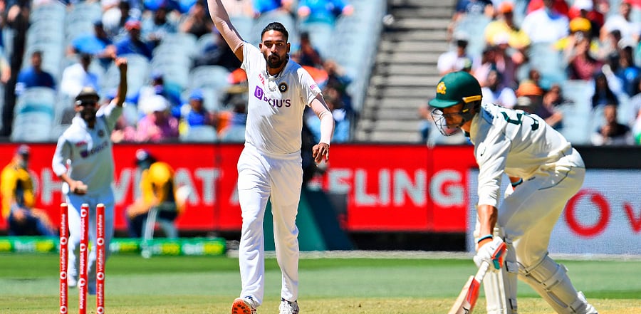 Mohammed Siraj (C) deflects a ball onto the stumps as Australia's Mitchell Starc (R) looks on during the fourth day of the second cricket Test match between Australia and India. Credit: AFP Photo
