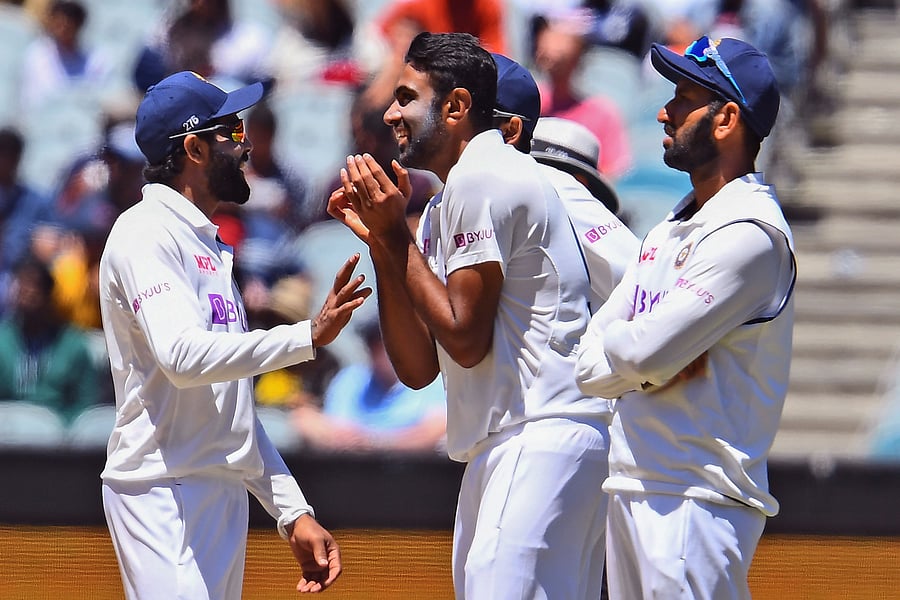 India's Ravi Ashwin (C) is congratualed by teammates Ravi Jadeja (L) and Cheteshwar Pujara (R) after dismissing Australia's Josh Hazlewood on the fourth day of the second cricket Test match between Australia and India played at the MCG in Melbourne. Credit: AFP