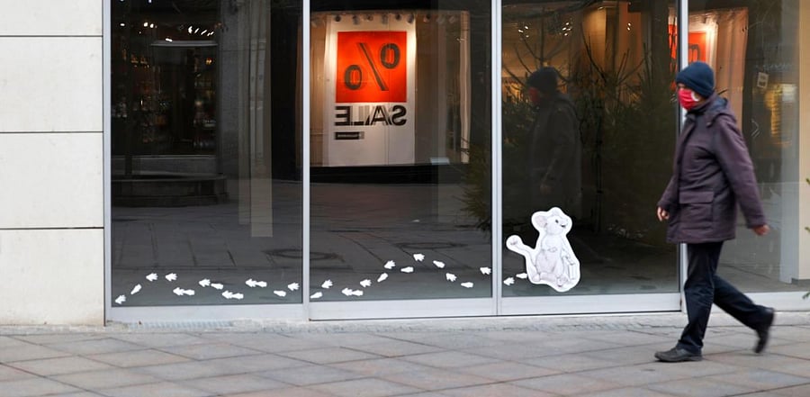 People walk past an empty shop in the "Breite Strasse" downtown in the northern German city of Luebeck. Credit: AFP