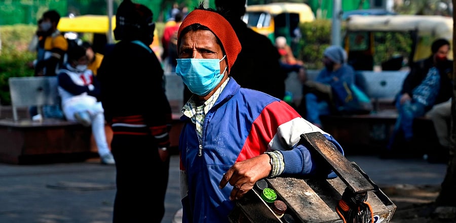 A cobbler wearing a facemask as a preventive measure against the Covid-19. Credit: AFP Photo