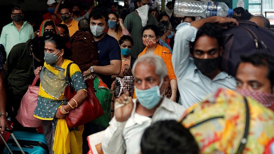 People wearing protective masks exit a railway station amid the spread of the coronavirus disease. Credit: Reuters Photo