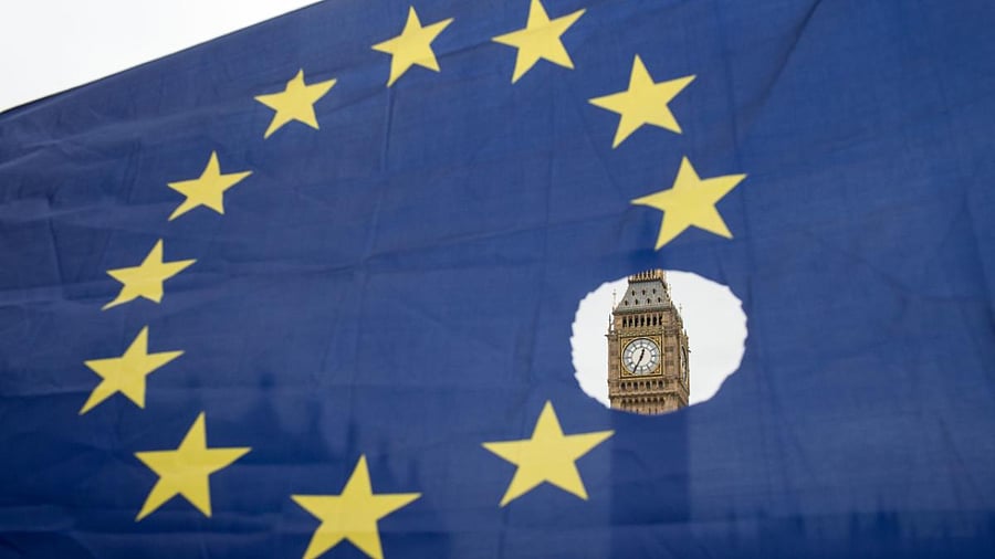 A pro-remain protester holds up an EU flag with one of the stars symbolically cut out in front of the Houses of Parliament shortly after British Prime Minister Theresa May announced to the House of Commons that Article 50 had been triggered in London. Credit: AFP File Photo