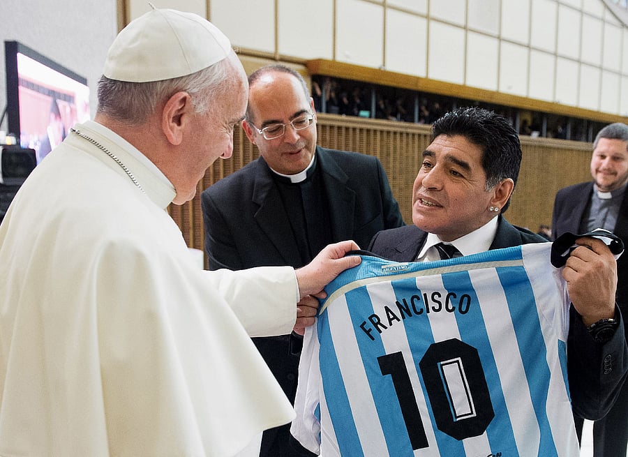 Argentinian former football player Diego Armando Maradona (R) presenting a personalised Argentina jersey to Pope Francis during a meeting with organizers, players and guests of the intereligious "match for peace" football game, in Paul VI hall at the Vatican. - The first pope from Latin America called Diego Maradona a "poet" on the field, as he weighed in on the joys of sport, in a 31-page interview about sports which took place in early December at the Vatican and was published on January 2, 2021 in Italy's La Gazzetta dello Sport. Credit: Vatican press office/AFP
