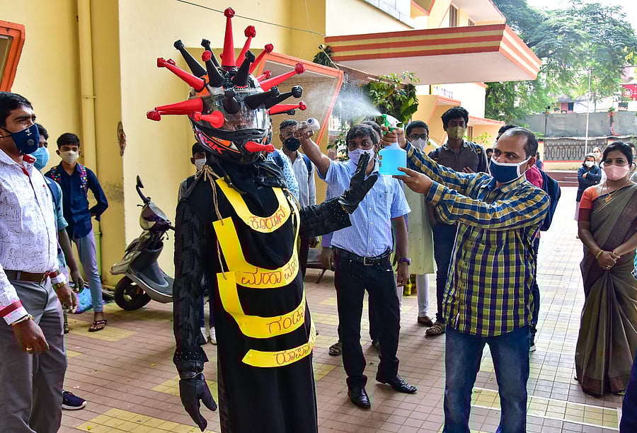 A volunteer wears a dress themed on coronavirus during a demonstration to create awareness at a school that was reopened after the authorities allowed to conduct classes for SSLC and 12th Standard students, in Bengaluru. Credit: PTI.
