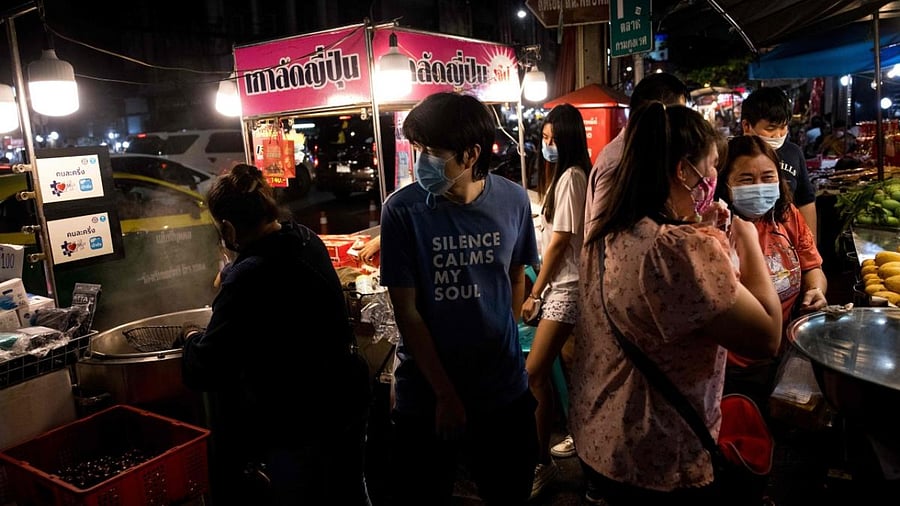 People wearing face masks walk among street vendors in Chinatown, Bangkok on January 2, 2021, after the Thailand's capital imposed temporary lockdown measures aimed at curbing the rising coronavirus toll. Credit: AFP.