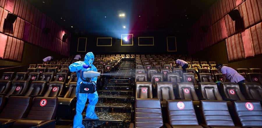 A worker wearing PPE kit sanitises a cinema hall in Chennai. Credit: PTI Photo