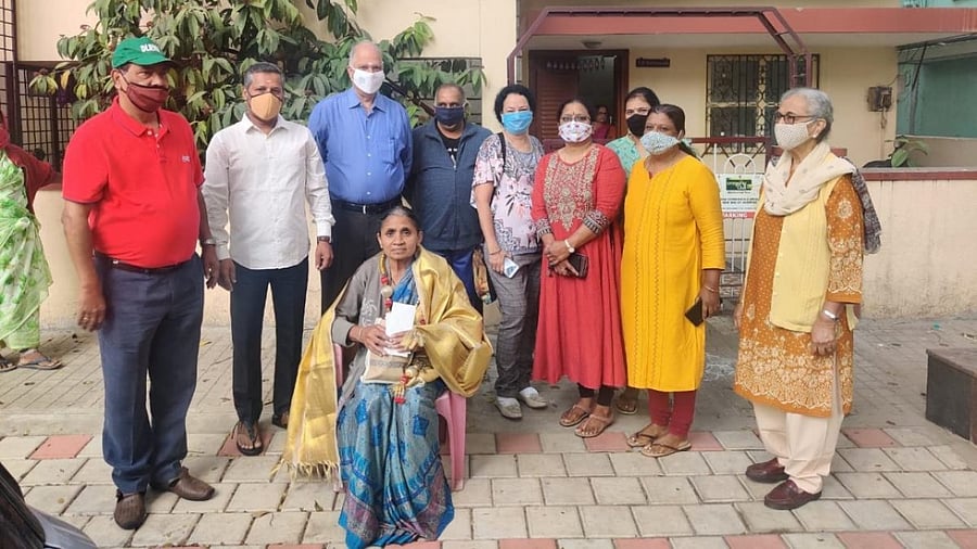 Members of the Domlur Layout Residents Welfare Association felicitate civic worker Puttamma. Credit: Special arrangement.