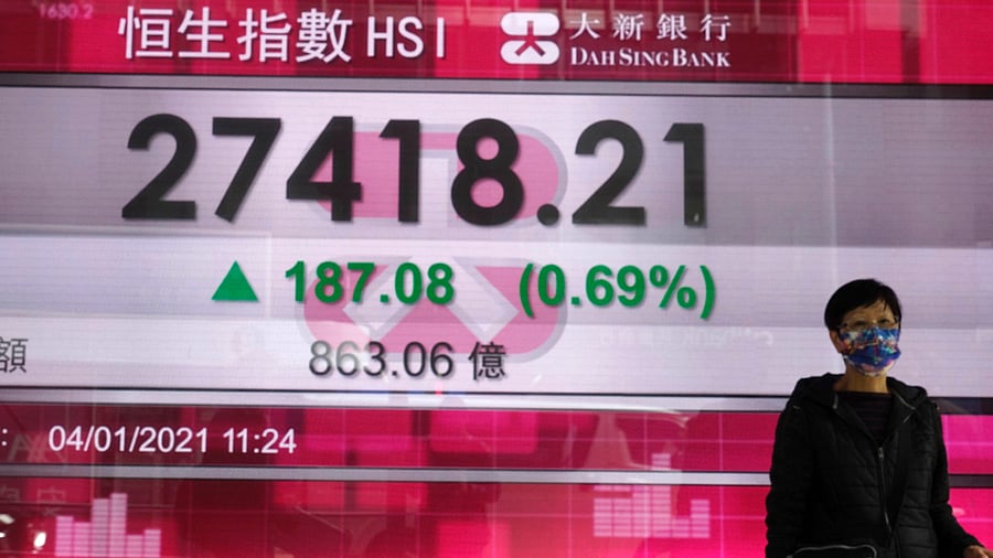 Hong Kong"A woman walks past a bank's electronic board showing the Hong Kong share index at Hong Kong Stock Exchange. Credit: AP Photo