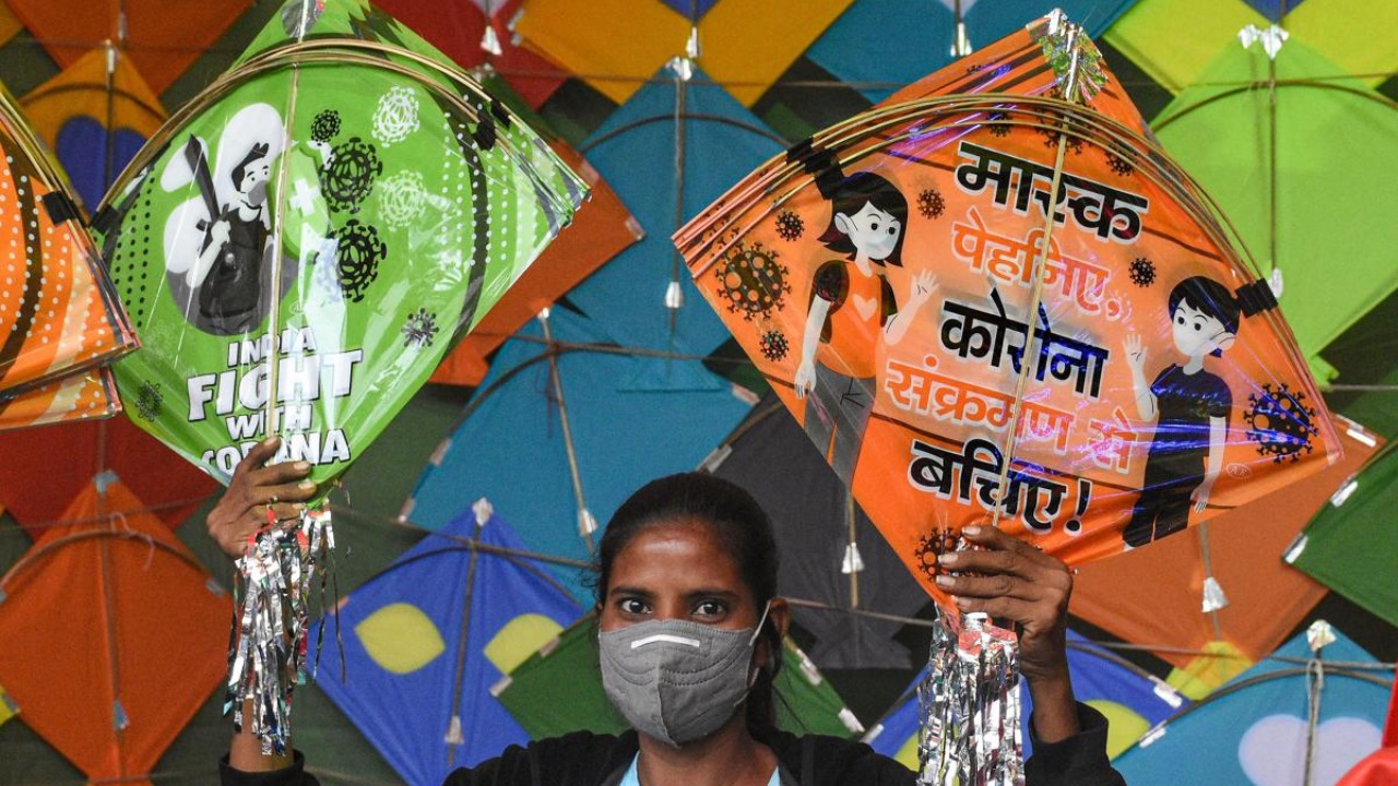 A vendor shows kites with awareness messages on Covid-19 ahead 'Uttarayan' festival in Surat. Credit: PTI.