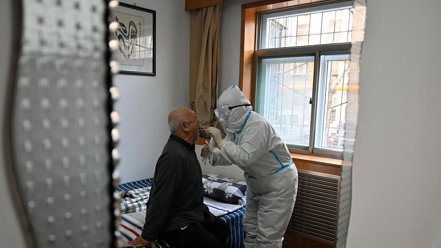 A medical worker takes a swab sample from an elder man, following the largest domestic outbreak of the Covid-19 coronavirus in six months in Shijiazhaung, in northern China's Hebei province. Credit: AFP File Photo