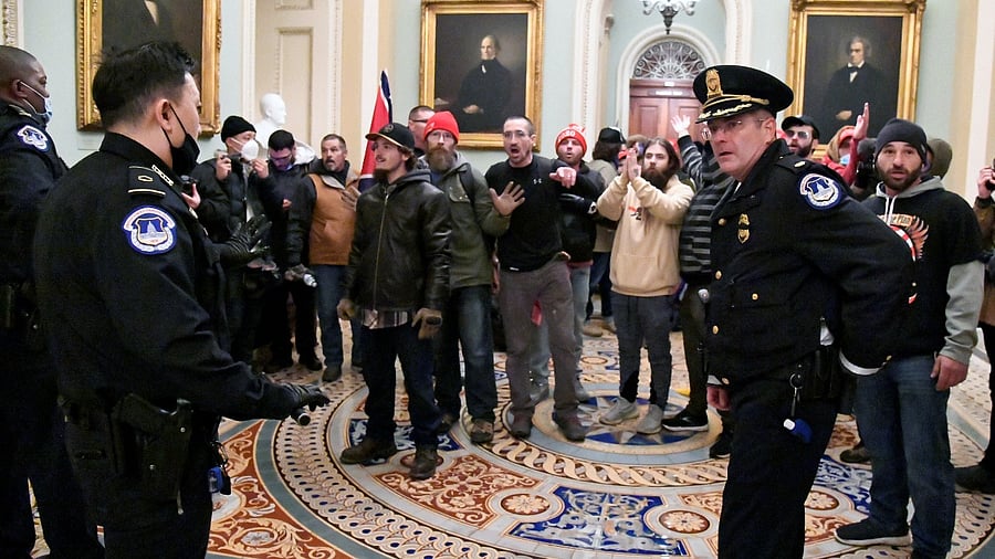 Police speak to supporters of US President Donald Trump as they demonstrate on the second floor of the US Capitol near the entrance to the Senate after breaching security defenses, in Washington, US, January 6, 2021. Credit: Reuters Photo/Mike Theiler