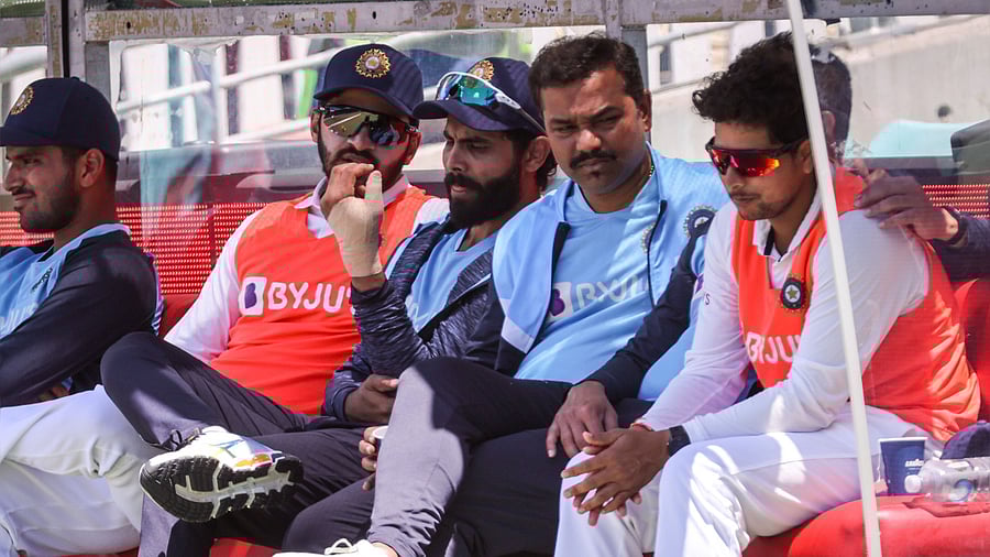 Ravindra Jadeja (C) holds up his injured hand as he sits on a team bench during day four of the third cricket Test match between Australia and India. Credit: AFP Photo