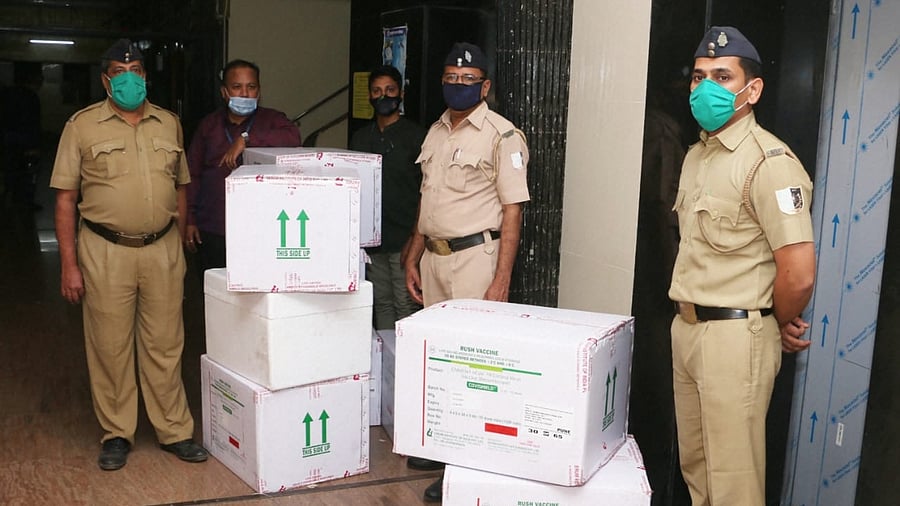 Security personnel stand guard near the Covishield vaccines, dispatched from Pune's Serum Institute of India at a cold storage facility in Mumbai. Credit: PTI Photo