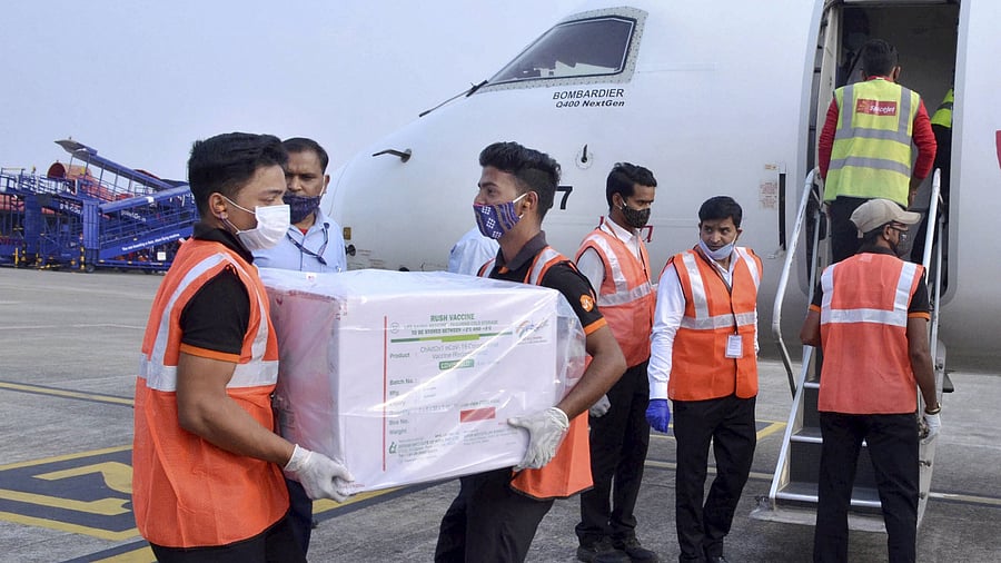 Workers unload from a plane the first consignment of Covishield vaccines, dispatched from Serum Institute of India, at Biju Patnaik Airport in Bhubaneswar. Credit: PTI Photo